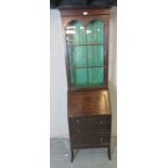 An Edwardian mahogany narrow bureau/display cabinet, the fall front opening onto a fitted