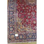 A Persian Majafabud carpet blue central pattern and border on a deep claret ground. Excellent