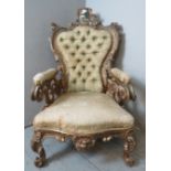 A vintage French giltwood button back armchair in a 19th century Rococo style, asymmetrically carved