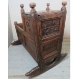 A 17th Century oak rocking crib, with relief carved panel bearing date 1674 and pierced carved