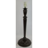 A large turned mahogany candlestick style table lamp. Height 58cm. Condition report: Chip to lip.