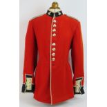 An Irish Guards ceremonial scarlet tunic with Queen's crown bright buttons, mounted on a torso