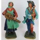 A pair of French pottery figurines depicting a couple of peasant musicians, incised marks to base.