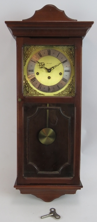 A contemporary Metamec striking & chiming wall clock in mahogany style case. Pendulum & key present.