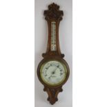 An Edwardian carved oak cased wheel barometer by Aitcheson & Co, London and Leeds. Height 90cm.