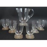 A seven piece glass & jug set by Rene Lalique in Paquerette pattern, model number 5329, circa