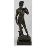 A bronze figure of David After Michelangelo mounted on a black marble base, unsigned. Height 38.5cm.