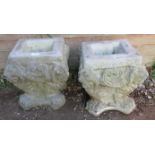 A pair of nicely weathered reconstituted stone planters with lion mask corners, on lions paw feet.