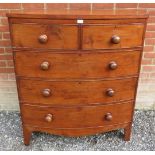 A Georgian mahogany bowfront chest of two short over three long cock beaded drawers, retaining the