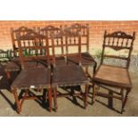 Five Edwardian oak dining chairs with embossed leather seats, on reeded supports with stretchers,