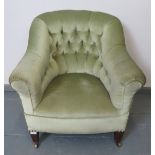 A turn of the century button back armchair, upholstered in green velvet, on tapering square supports