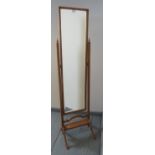 An Edwardian oak bevelled cheval mirror, with square uprights and turned finials, on splayed