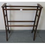 A turn of the century mahogany double towel rail, strung with satinwood, featuring turned side