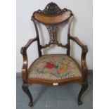 A fine Edwardian mahogany elbow chair, featuring an intricately carved and pierced backrest with