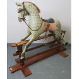 A vintage dapple grey rocking horse, with leather reigns, bridle & saddle and real horsehair