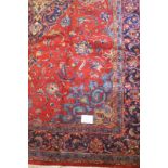 A superb Sarough carpet with central blue diamond motif on a red ground in excellent condition.