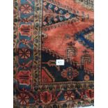 A Persian Vles carpet, blue and taype motifs on a burnt orange/red ground. Condition report: In very