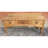 An antique stripped pine sideboard of three drawers with turned wooden knob handles, on square