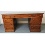 A Victorian oak kneehole pedestal desk with inset gilt tooled green leather writing surface, housing