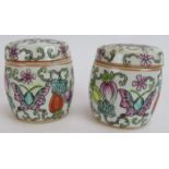 A pair of small hand decorated Chinese covered jars, each with an erotic scene painted inside the