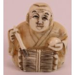 A Japanese Meiji period carved ivory netsuke in the form of a sitting man, signed to base. Height