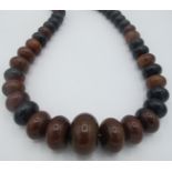 A large amber type graduated necklace, centre bead, approx 40mm across, 18" long. Condition