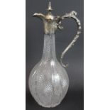 A turn of the century cut glass claret jug with silver plated mount and intricately engraved