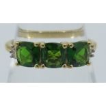 Faceted cushion cut Russian diopside trilogy ring with tapered baguette diamonds to shoulders,