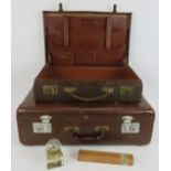 A vintage fitted leather briefcase, a small vintage suitcase, an antique glass inkwell and a