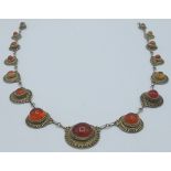 A fine amber mounted yellow metal necklace consisting of fifteen graduated amber discs joined