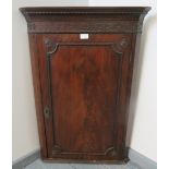 A Georgian mahogany corner cupboard with dentil cornice and blind fret frieze, of three internal