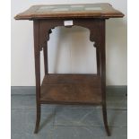 An Arts & Crafts oak tile topped two tier occasional table/plant stand, on outswept supports.