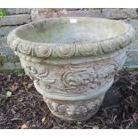 A nicely weathered reconstituted stone plant pot with relief moulding in a Neo-Classical taste,