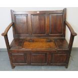 An 18th century oak settle of excellent colour, with fielded panels to backrest, front and sides and