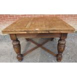 An early 20th century medium oak draw leaf extending dining table, on baluster turned and fluted