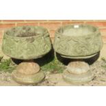 A pair of nicely weathered reconstituted stone garden urns on plinths, with decoration carving in t