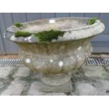A nicely weathered reconstituted stone garden urn on stand in the Neo-Classical taste. Condition