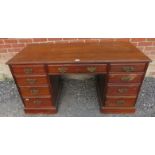 An Edwardian mahogany kneehole desk, housing a configuration of nine graduated drawer, with fancy