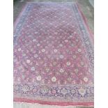 A good quality huge Liberty & Co 'Mahal' carpet with repeat floral design on a claret ground surrou