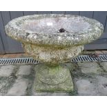A nicely weathered reconstituted stone garden urn on stand in the Neo-Classical taste. Condition