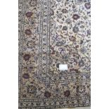 A good Persian Kashan carpet with a central pattern motif on a cream ground in good condition and