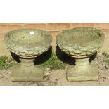 A pair of nicely weathered reconstituted stone garden planters in the form of woven baskets on