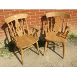 A pair of 19th century style light fruitwood Windsor open sided armchairs, on turned supports with