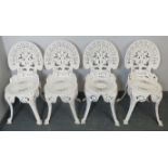 A set of four heavy quality Victorian style cast iron garden chairs painted white, on scrolled supp