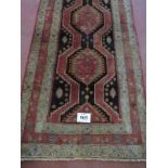 A superb Persian Heriz runner, a repeat central pattern on a brown ground all highlighted with