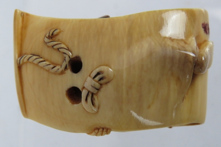 A finely carved Japanese ivory Netsuke, Meiji period, of a semi nude female on a scroll decorated in - Image 2 of 4