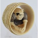 A finely carved Japanese ivory Netsuke of a cooper working in a barrel. Height: 4.8cm. Signed to