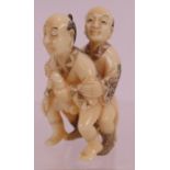 A finely carved erotic Japanese ivory Netsuke, early 20th century, featuring two men and decorated