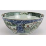 A large Chinese porcelain bowl decorated in the Famille Verte style with enamelled panels
