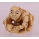 A finely carved Japanese ivory Netsuke, early 20th century of a crouching figure. Height: 2.8cm.